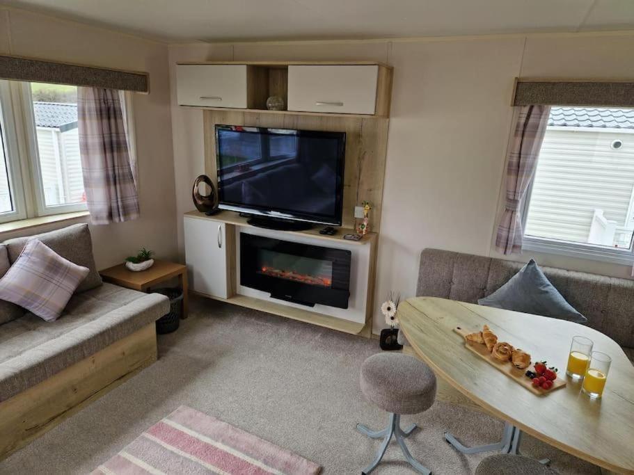 韦茅斯Weymouth Bay Haven, Preston Road的客厅配有电视、沙发和桌子
