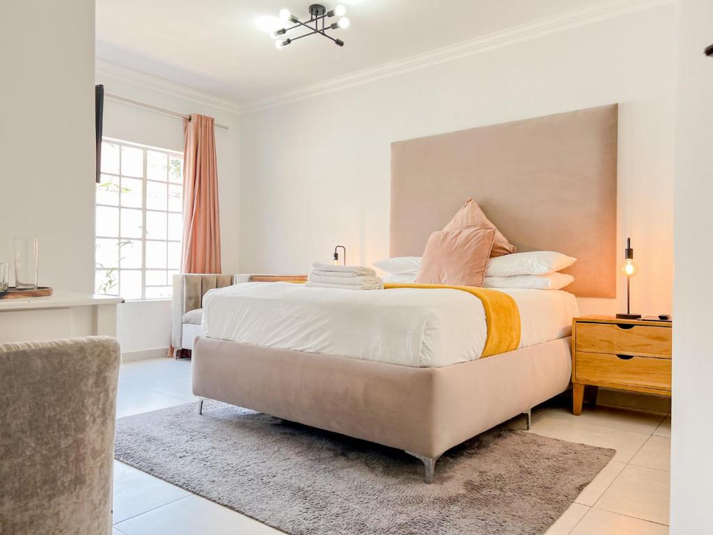 比勒陀利亚Amoris Guesthouse - In Brooklyn的卧室配有一张带白色床单和枕头的大床。