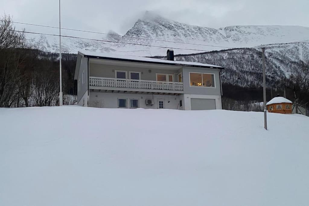 特罗姆瑟Skogstad Ferie og fritid的雪覆盖的山顶上的房子
