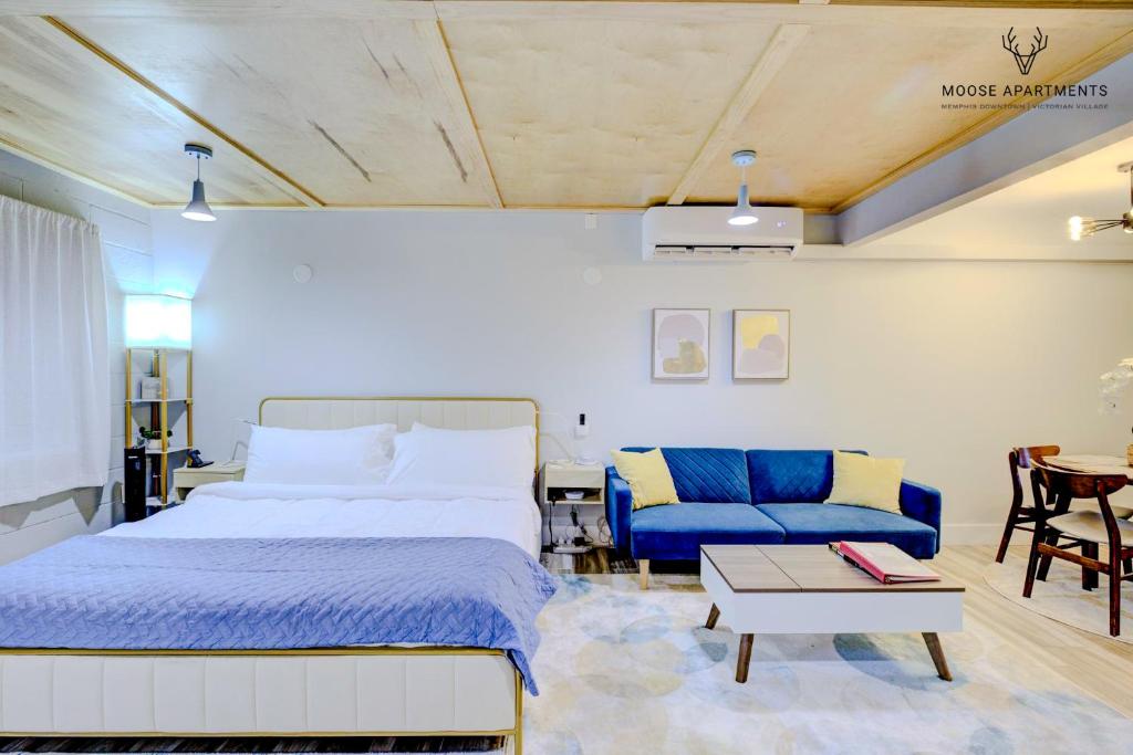 孟菲斯The Moose #5 - Modern Comfy Studio with King Bed, Free Parking & Fast WiFi的一间卧室配有一张床和一张蓝色的沙发