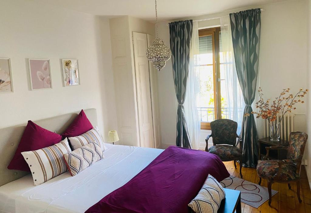 日内瓦HOCORAS Apartment的一间卧室配有一张带紫色床单的大床