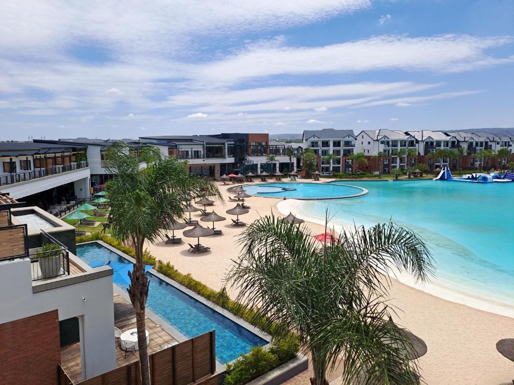 比勒陀利亚THE BLYDE Holiday Apartments的享有棕榈树度假村游泳池的空中景致