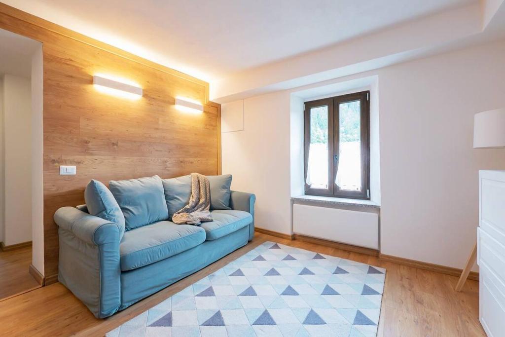 Piatta[IHost Luxury Flat Bormio] - Centrale 69的客厅设有蓝色的沙发和窗户。