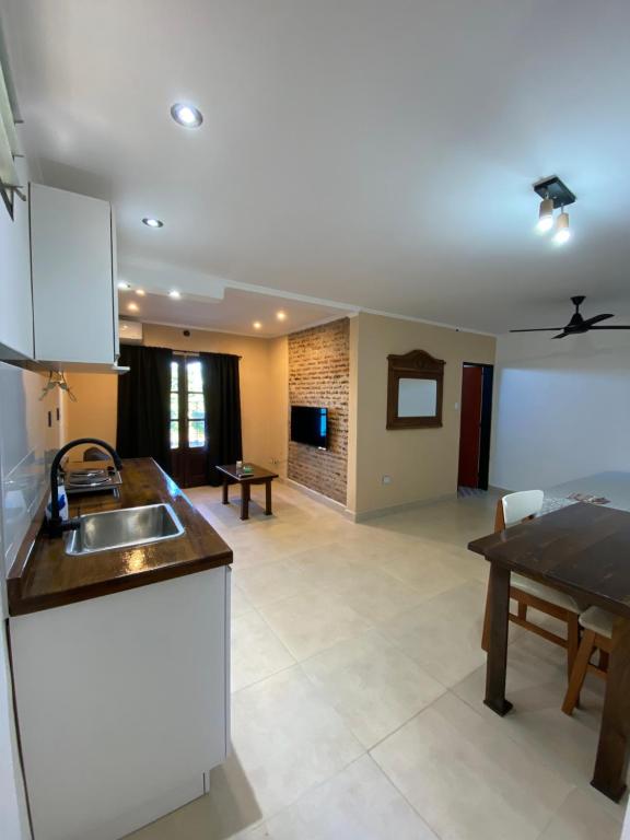 拉巴斯Monoambiente La Paz的厨房以及带水槽和桌子的客厅。