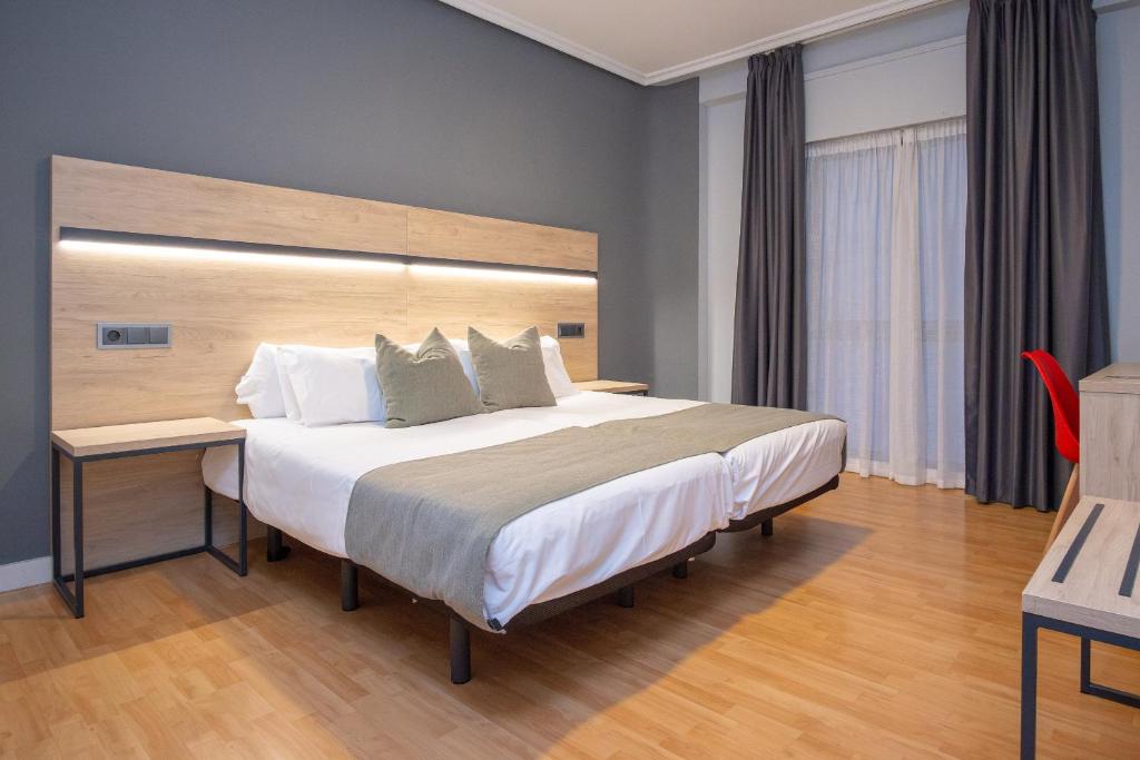 萨拉戈萨AZ Hotel El Príncipe的一间卧室配有一张大床和木制床头板