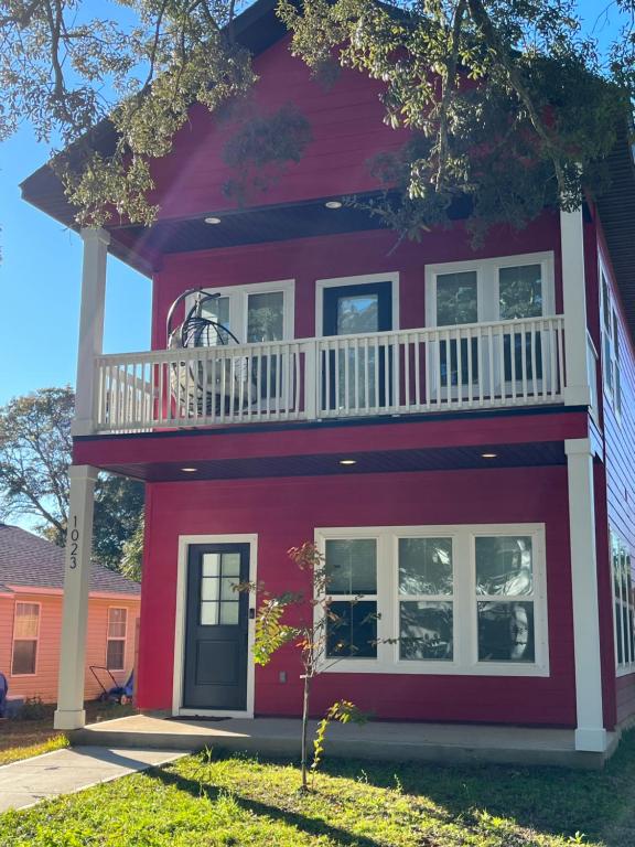 彭萨科拉The Clifford House的红色的房子,上面设有阳台