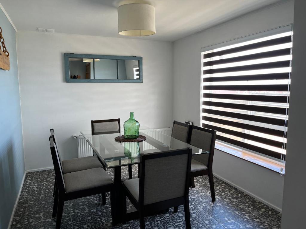 纳塔列斯港Casa Entre Glaciares的一间设有玻璃桌和椅子的用餐室