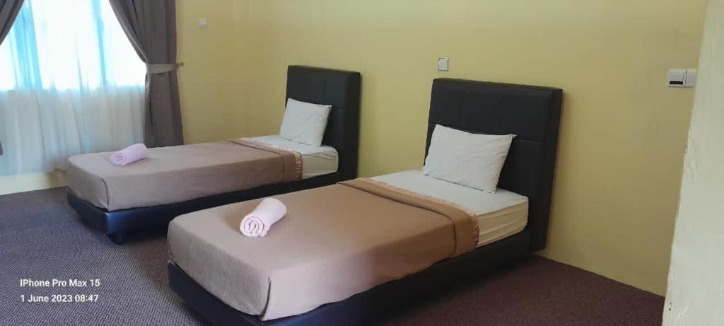 Kota BharuAlia Tiara River and Beach Resort的两张位于酒店客房的床,配有粉红色枕头