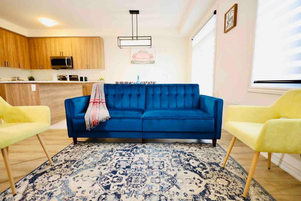 FergusPovey Retreat Centre Wellington (Fergus Elora)的客厅配有一张蓝色沙发,配有两把椅子