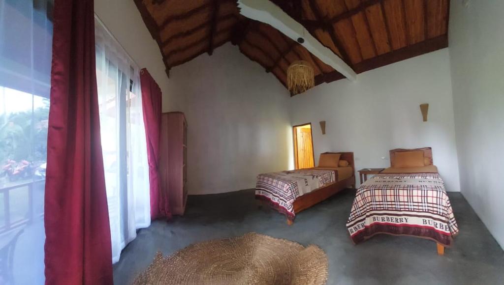 KruiKambuna Bungalow的一间卧室设有两张床和窗户。