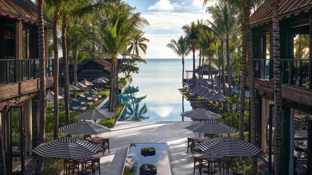 曾蒙海滩Kimpton Kitalay Samui, an IHG Hotel的阳台配有桌子和遮阳伞,享有海景。