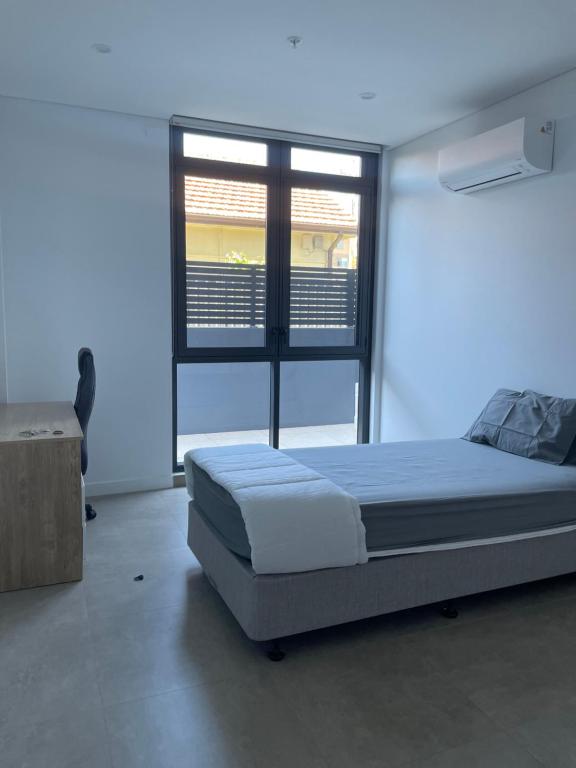 布莱克敦The Cozy Retreat, 1 Oxford St, Blacktown , NSW的一间卧室设有一张大床和一个窗户。