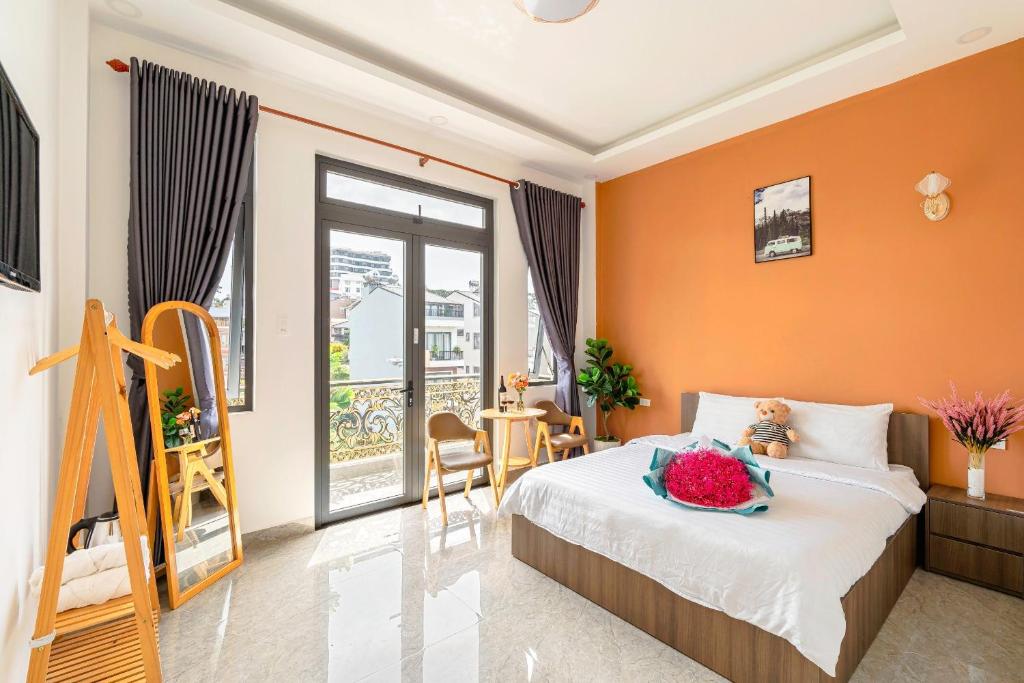 大叻Nhat Minh Hotel Dalat的一间卧室拥有橙色的墙壁和一张鲜花盛开的床。