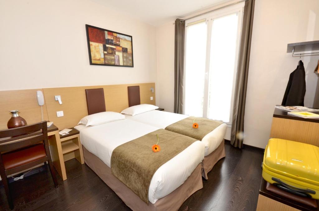 巴黎苏尔斯酒店的酒店客房配有两张床和一张书桌