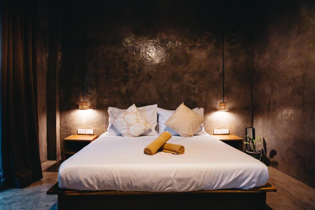 卢纳将军城The Ohm Siargao Resort的卧室配有一张带两个灯的大白色床