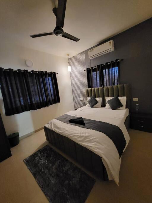 罗纳瓦拉THE PERFECT STAYS: SUPREME BLISS VILLA的一间卧室配有一张大床和吊扇