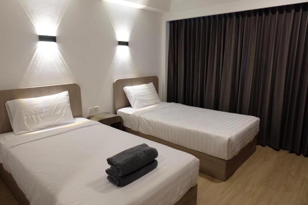 彭世洛友通酒店的酒店客房,配有两张床和床上的行李箱