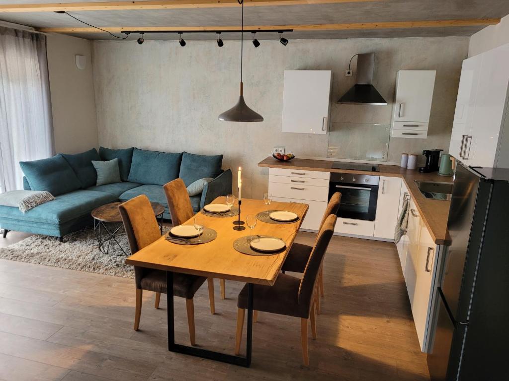 豪恩斯泰因Wohnung unterm Burghalder - Direkt am Waldrand的厨房以及带木桌和椅子的客厅。