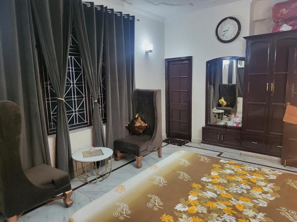 瑞诗凯诗Luxury Ganges view Villa Homestay (Vacaow)的客厅配有床、椅子和时钟