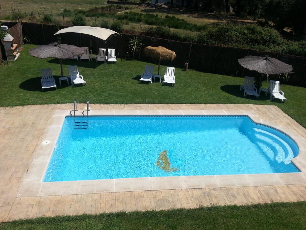 La CodoseraCasa Rural Sierra San Mamede的享有带椅子和遮阳伞的游泳池的上方景色