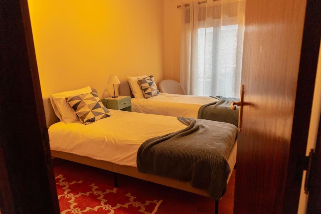 科维良Casa Angulosa的一间卧室设有两张床和窗户。