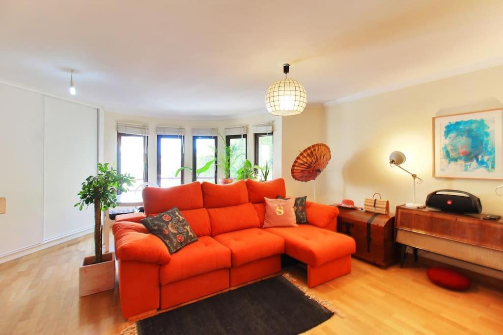里斯本Charming apartment ideally located in Lisbon的客厅里设有橙色沙发,配有窗户