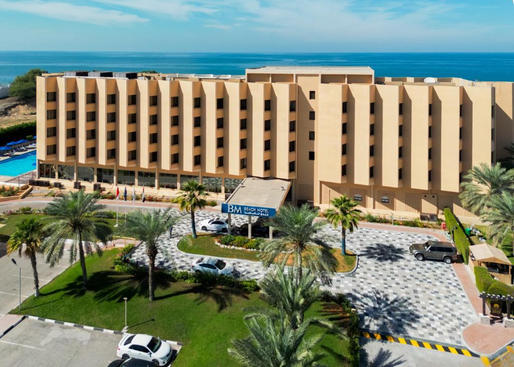 拉斯阿尔卡麦BM Beach Hotel的享有棕榈树酒店和大海的空中景致