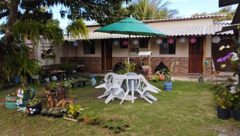 普拉杜Residencial Pita的院子里的桌子和椅子以及雨伞