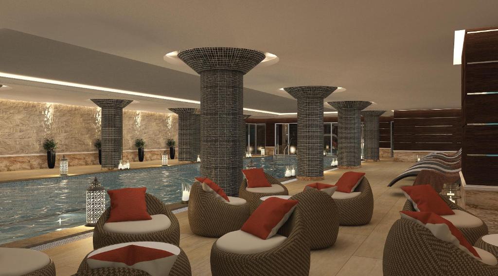 苏莱曼尼亚Mihrako Hotel & Spa的酒店大堂设有游泳池和椅子