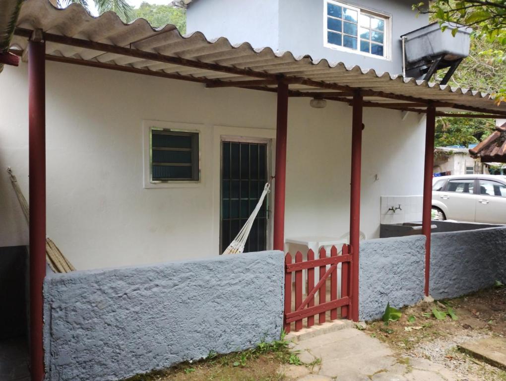 圣塞巴斯蒂安Casinha Pescador的一座有红色门和栅栏的房子