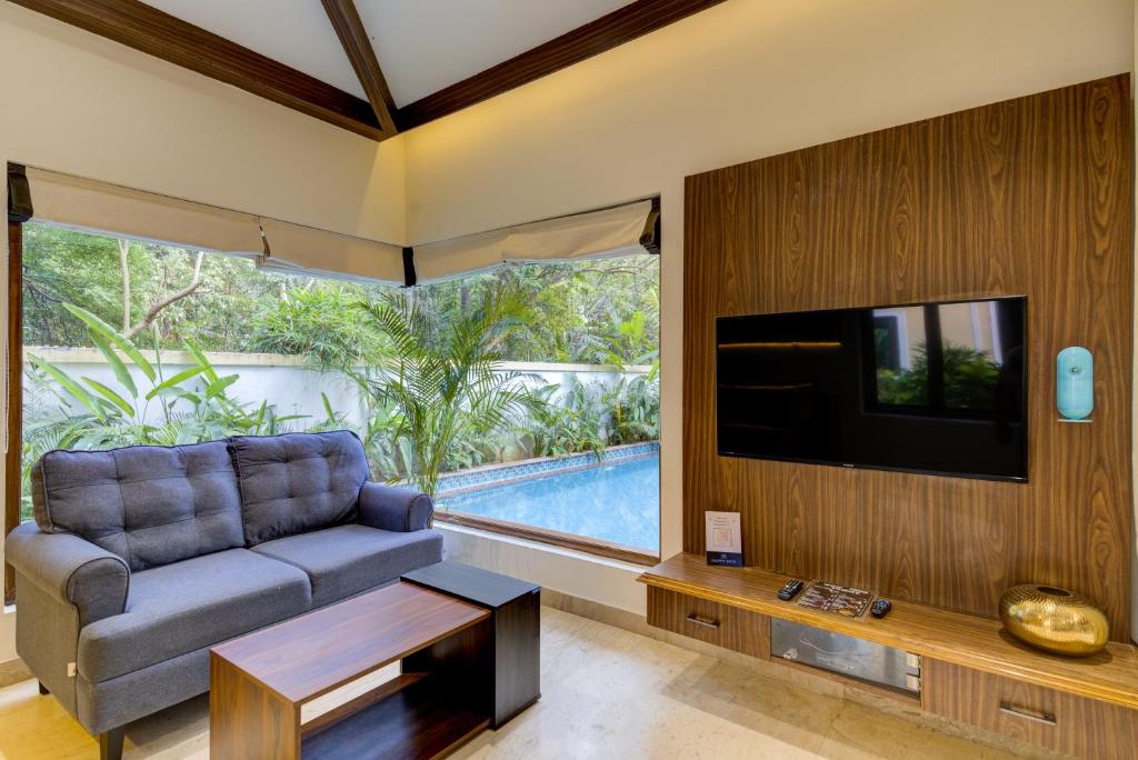 萨利加奥Tropical villa by Happyinch的带沙发和电视的客厅以及游泳池。