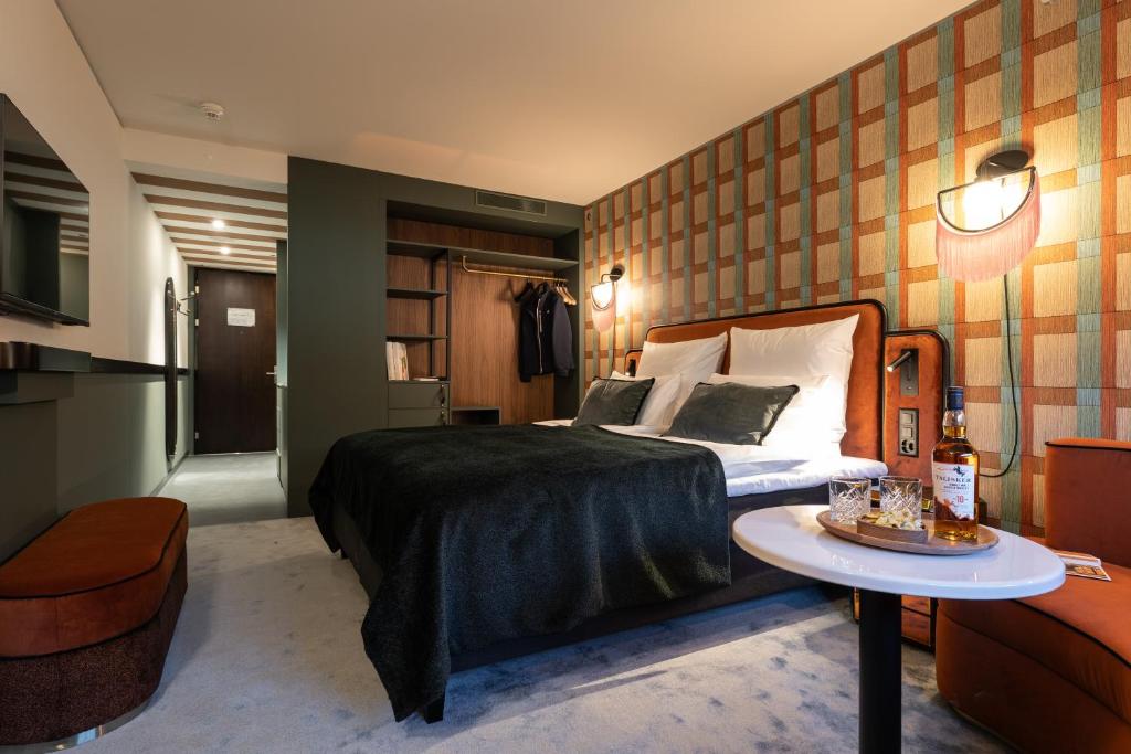 苏黎世The Home Hotel Zürich - a member of DESIGN HOTELS的一间酒店客房,配有一张床铺和一张桌子,上面有蛋糕