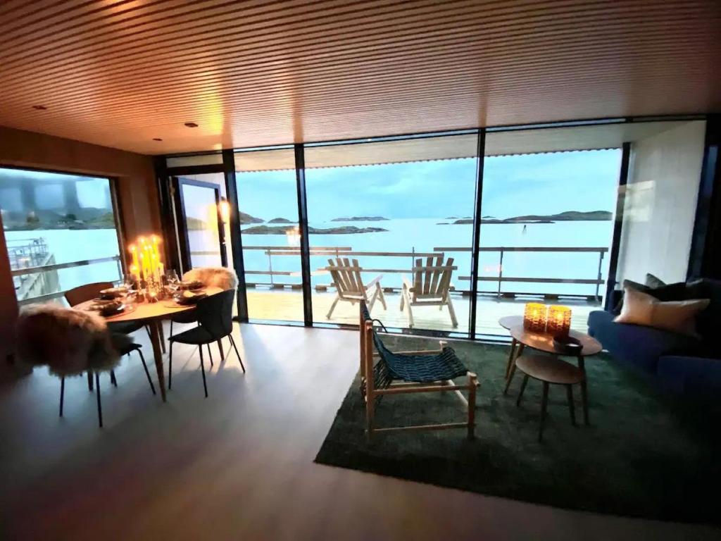 亨宁斯韦尔Waterfront apartment with panoramic sea view的客厅配有桌椅,享有海景。