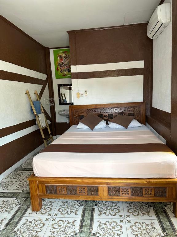 吉利特拉旺安Cozy Alfia Inn的一间卧室配有一张带木制床头板的床