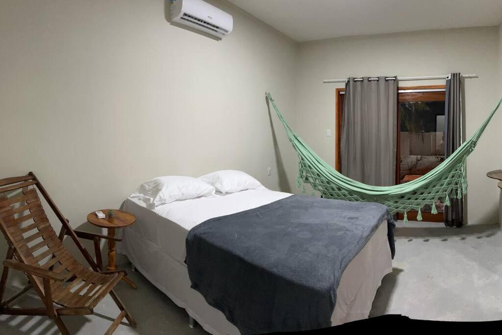伊塔雷马Casa Vento Maré.的一间卧室配有一张床和吊床