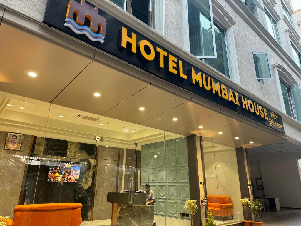 孟买Hotel Mumbai House, Malad的酒店大堂,有一个人站在大楼外