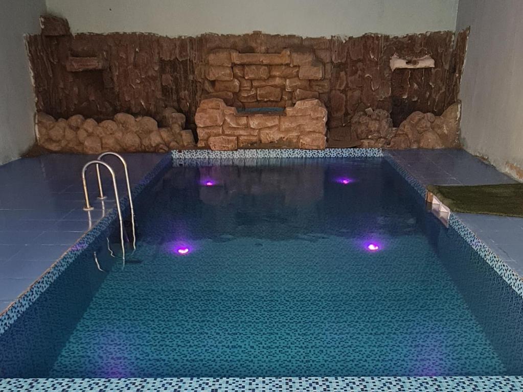 拉斯阿尔卡麦Al Fannan Farm - Family House的一座紫色灯光的大型游泳池