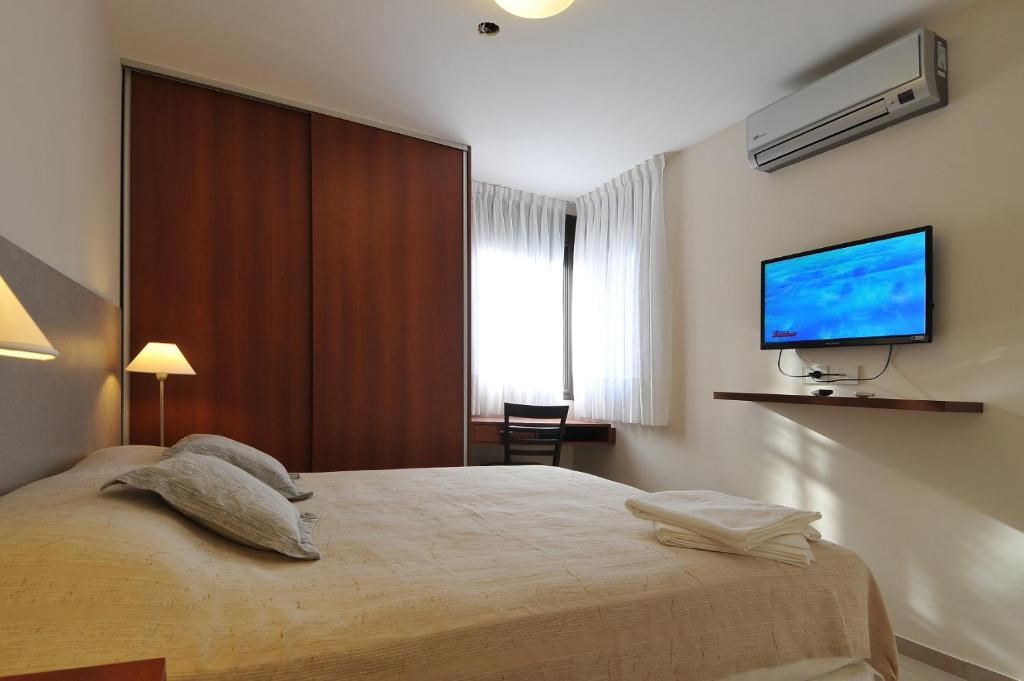 维拉卡洛斯帕兹AVIS Departamentos peatonal的一间卧室配有一张床和一台平面电视