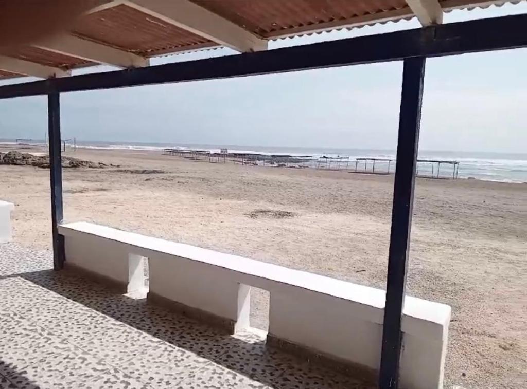 塔克纳Casa de playa de boca de río Primera fila - Playa planchon的坐在海滩上的白色长椅,与大海相连