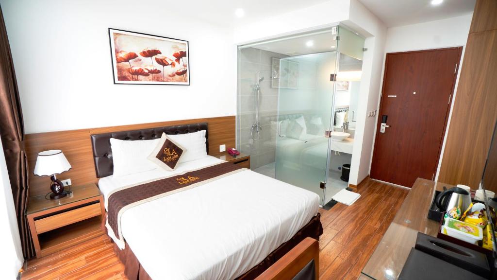 河内Lam Anh Hotel Dương Nội Hà Đông的一间卧室设有一张床和一个玻璃淋浴间