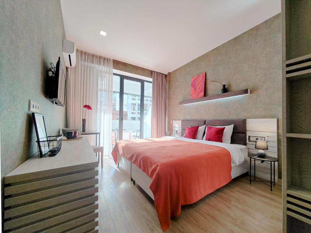 第比利斯Round Garden Hotel的一间卧室配有一张带红色毯子的大床