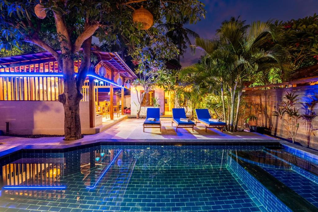 吉利阿尔Paradise Luxury Villa的一座房子旁的游泳池,配有蓝色的椅子