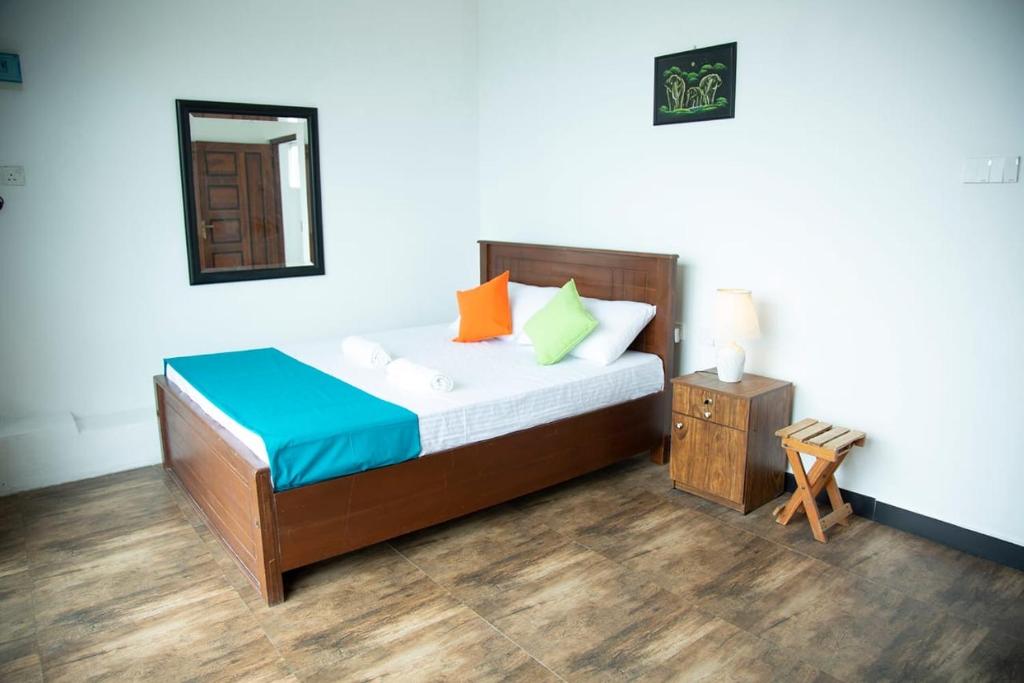 康提Eden Rock Luxurious Accommodation的一间卧室配有带橙色和蓝色枕头的床