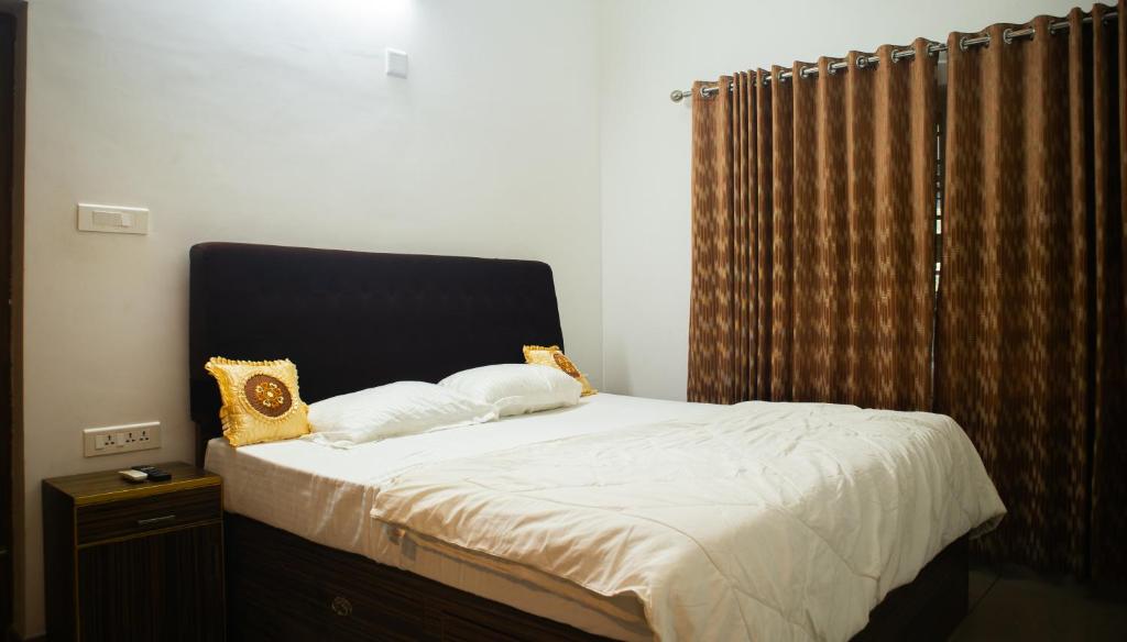 德里久尔Urban Oasis Homestay: AC Bedrooms的卧室内的一张带两个枕头的床