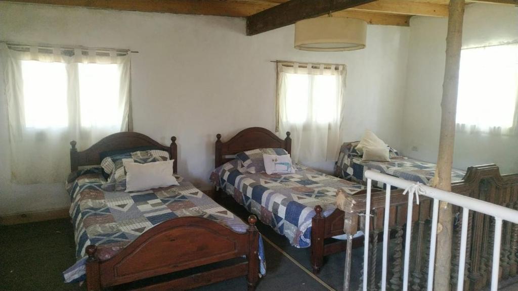 阿雷科河畔卡门Casa De Campo El Corral的一间卧室设有两张床和两个窗户。