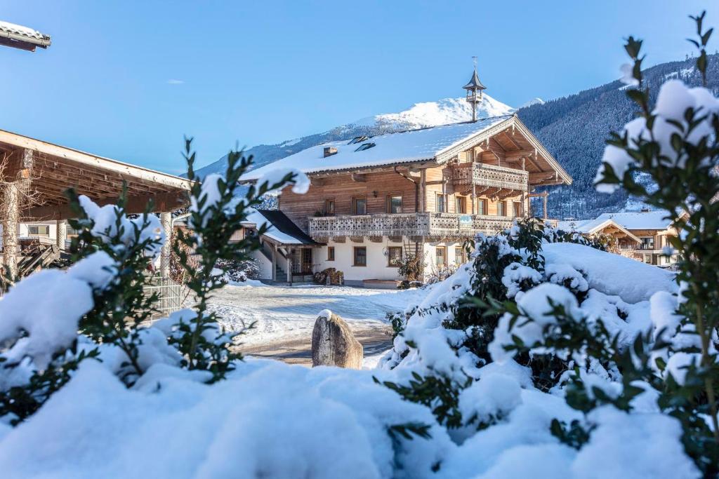 维尔德科格尔山麓布兰贝格Ferienwohnungen am Biobauernhof Lahner的山间有雪盖的房子