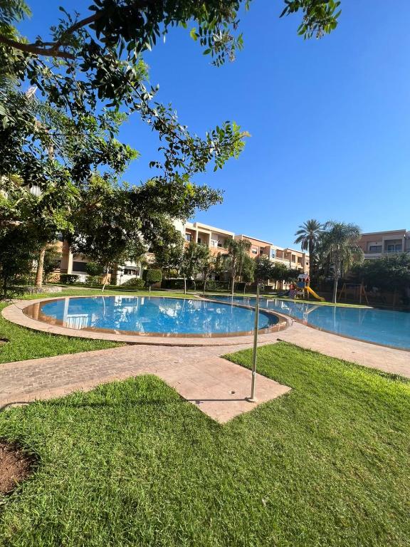马拉喀什Appart prestige de luxe的公园中央的游泳池
