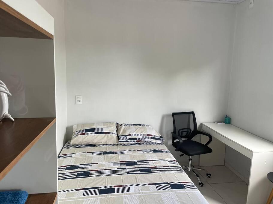 DianópolisApto Serras Gerais的一间卧室配有一张床、一张桌子和一把椅子
