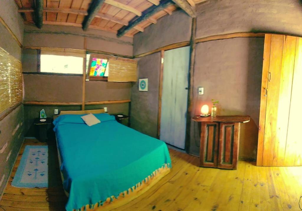 圣安娜Eco Posada Tierra Fértil的一间设有蓝色床和一张桌子的房间