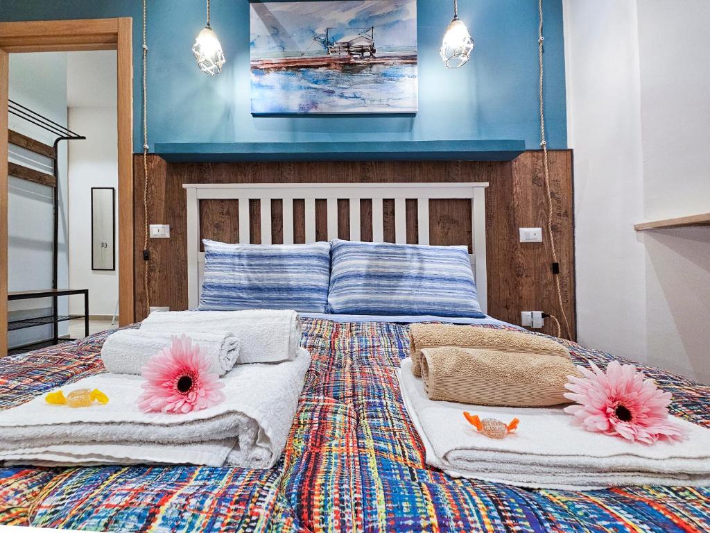 安科纳Marina di Piazzadarmi的一间卧室配有带毛巾和粉红色鲜花的床。